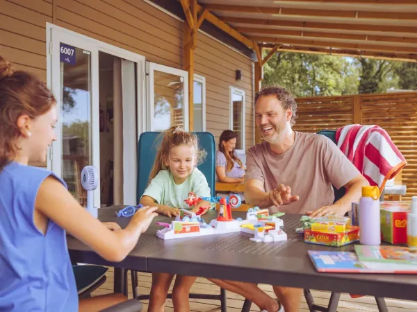 La famille joue à un jeu dans la véranda.