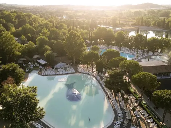 Vue d'ensemble des piscines dans un cadre verdoyant au camping Roan hu Altomincio village.