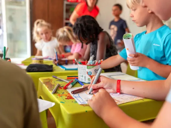 Les enfants dessinent au Club des enfants du camping Roan Château de Fonrives.