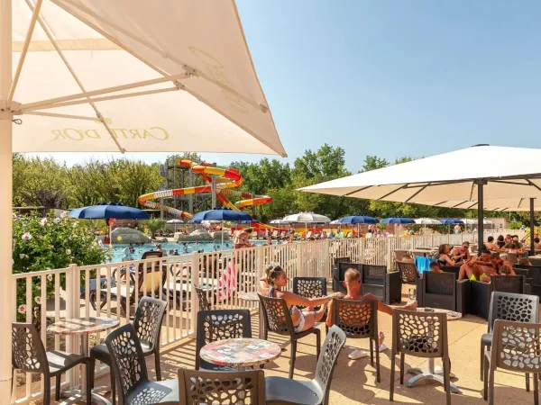 Terrasse au bord de la piscine du camping Roan Château de Fonrives.