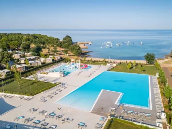 Piscine avec pataugeoire, toboggans et baie au camping Roan Park Umag.