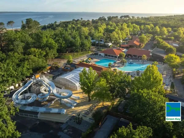 Vue de la piscine avec toboggan et de la mer au loin au Roan camping Mayotte Vacances.