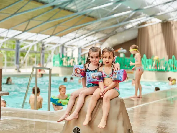 Deux filles sur une pierre dans la piscine couverte du camping Roan Terspegelt.