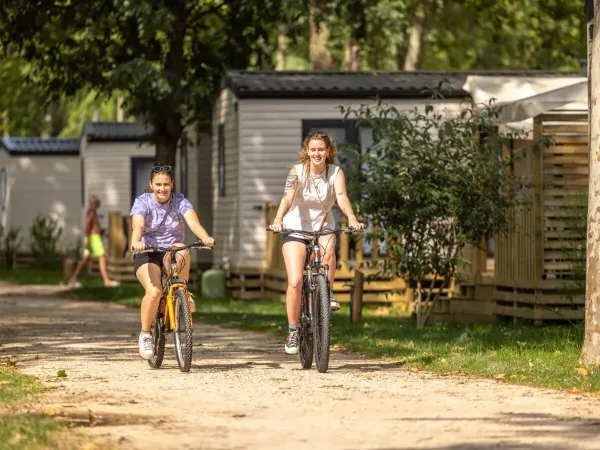 2 dames traversent à vélo le camping Roan Château de Galaure.