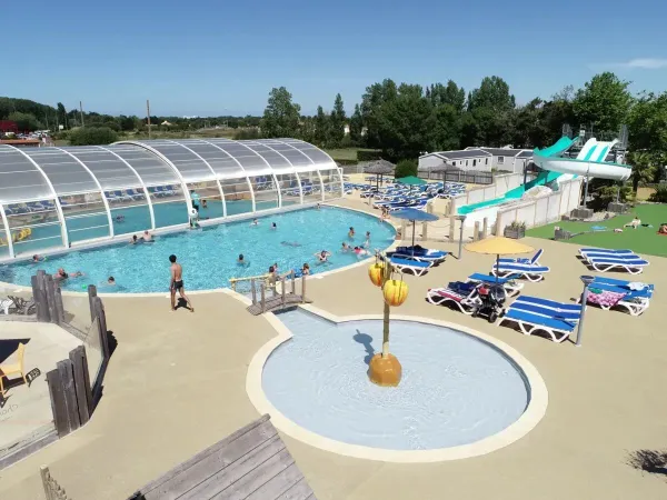 Vue d'ensemble de la piscine avec pataugeoire au camping Roan Le Domaine de Beaulieu.