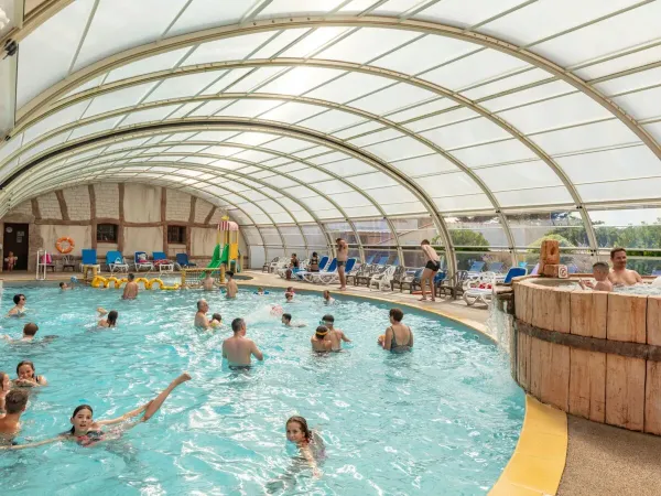 Piscine couverte avec toboggan aquatique au camping Roan Le Domaine de Beaulieu.