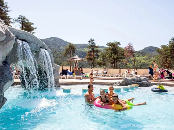 Une famille dans la piscine du camping Roan Les Collines de Castellane.