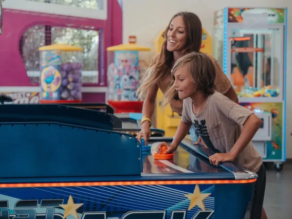 Mère et fils aux machines à sous du camping Roan Les Méditerranées Beach Garden.