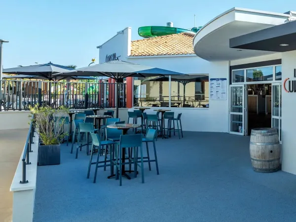 La terrasse et le salon du bar Clarys au camping Roan Le Domaine du Clarys.