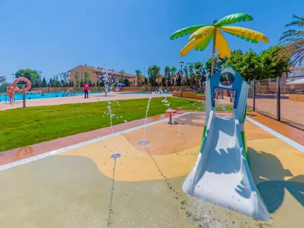 Toboggan aquatique pour les plus petits dans le parc à jets d'eau du camping Roan Platja Brava.