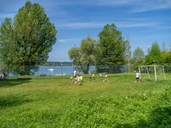 Des enfants jouent au football sur le terrain du camping Roan Okay Lido.