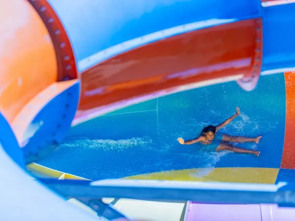 Une jeune fille glisse dans le péage du camping de Roan Le Soleil Méditerranée.