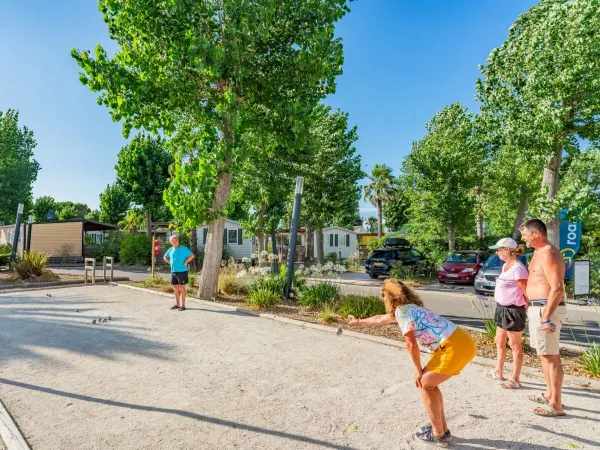 Une famille joue à la pétanque au camping Roan Le Napoléon.