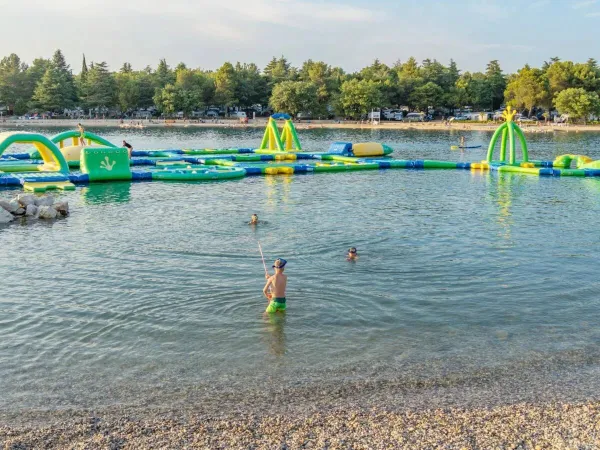 Mer avec jeux et châteaux gonflables dans l'eau au camping Roan Valkanela.