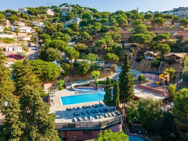 Camping Roan Cala Canyelles : aperçu de la piscine et de l'hébergement.