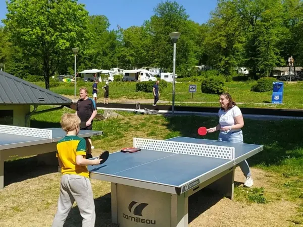 Une famille joue au ping-pong au camping Roan Le Lac des Vieilles Forges.