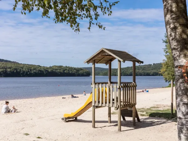 Petite aire de jeux sur la plage de sable du camping Roan Le Lac des Vieilles Forges.