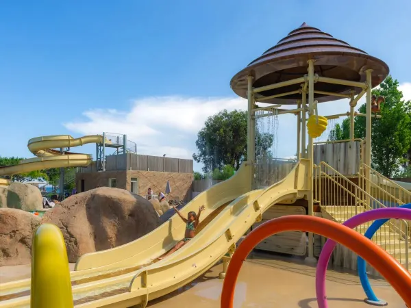 Une fille glisse sur le toboggan pour enfants du camping Roan Arinella Bianca.