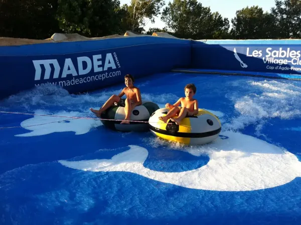 Tubing sur un simulateur de golf artificiel au camping Roan Les Sables d'Or.
