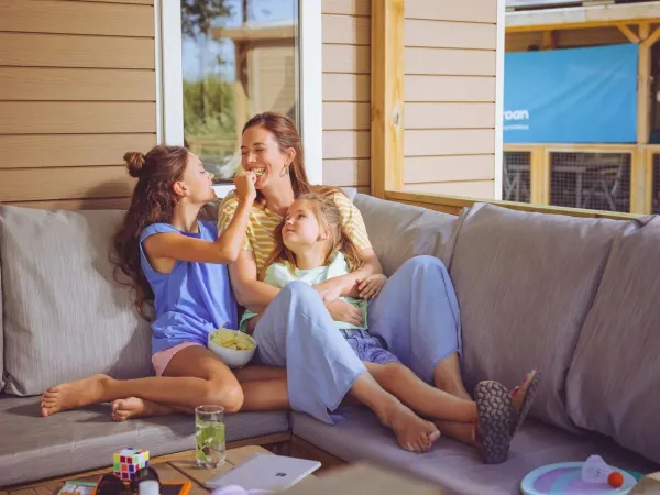 Mère et enfants s'amusent sur le canapé du salon de Roan.