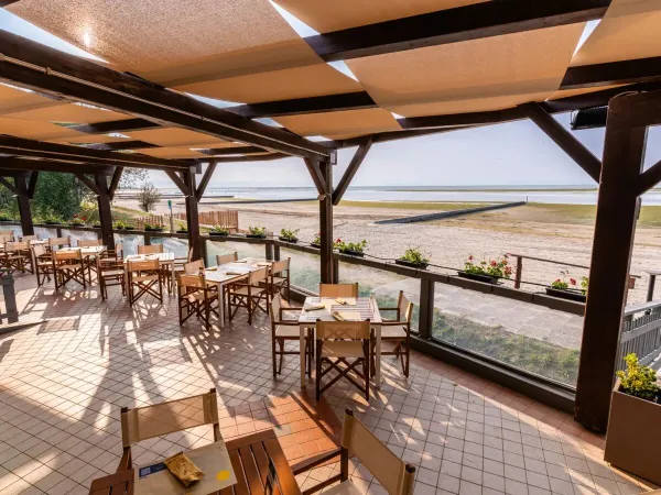 Restaurant avec vue sur la plage et la mer au camping Roan Tenuta Primero.