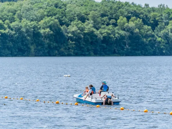 La famille profite des pédalos sur le lac au camping Roan Le Lac des Vieilles Forges.