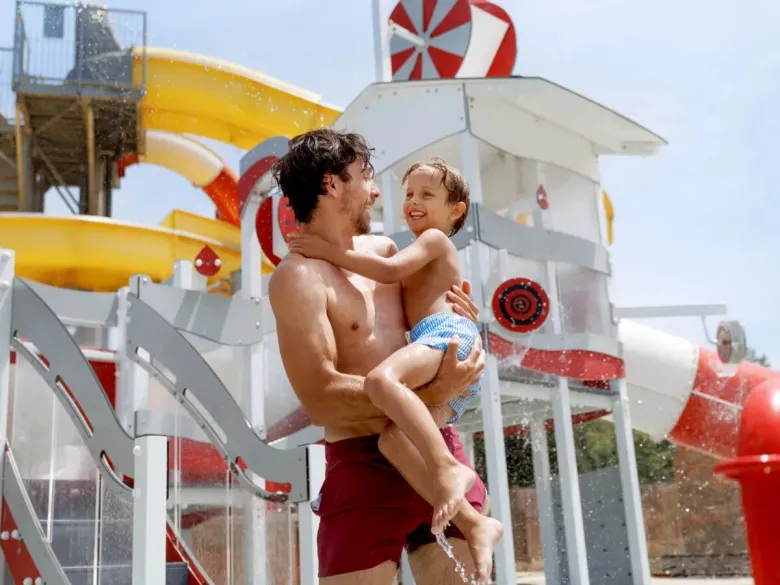 Homme et enfant jouant dans la piscine du camping de Roan.