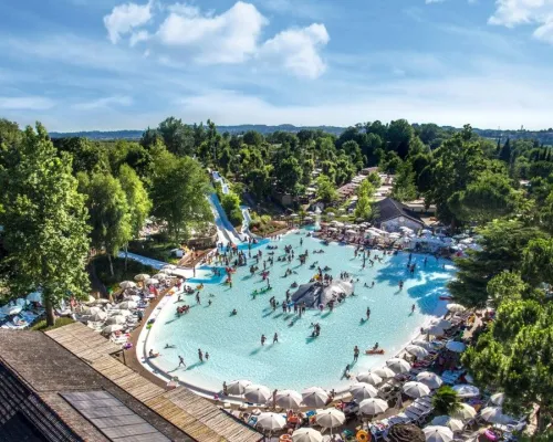 Vue d'ensemble de la piscine lagon avec toboggans au camping Roan hu Altomincio village.