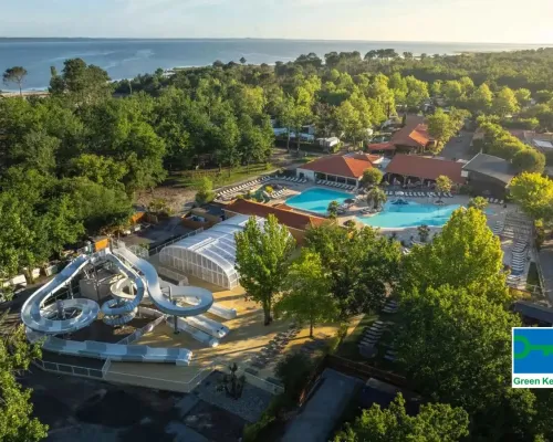 Vue de la piscine avec toboggan et de la mer au loin au Roan camping Mayotte Vacances.