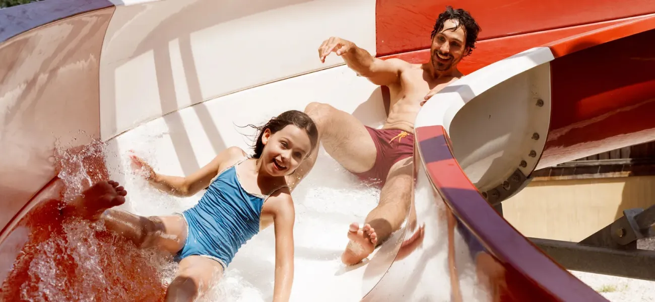 Deux filles courent dans une aire de jeux d'eau.